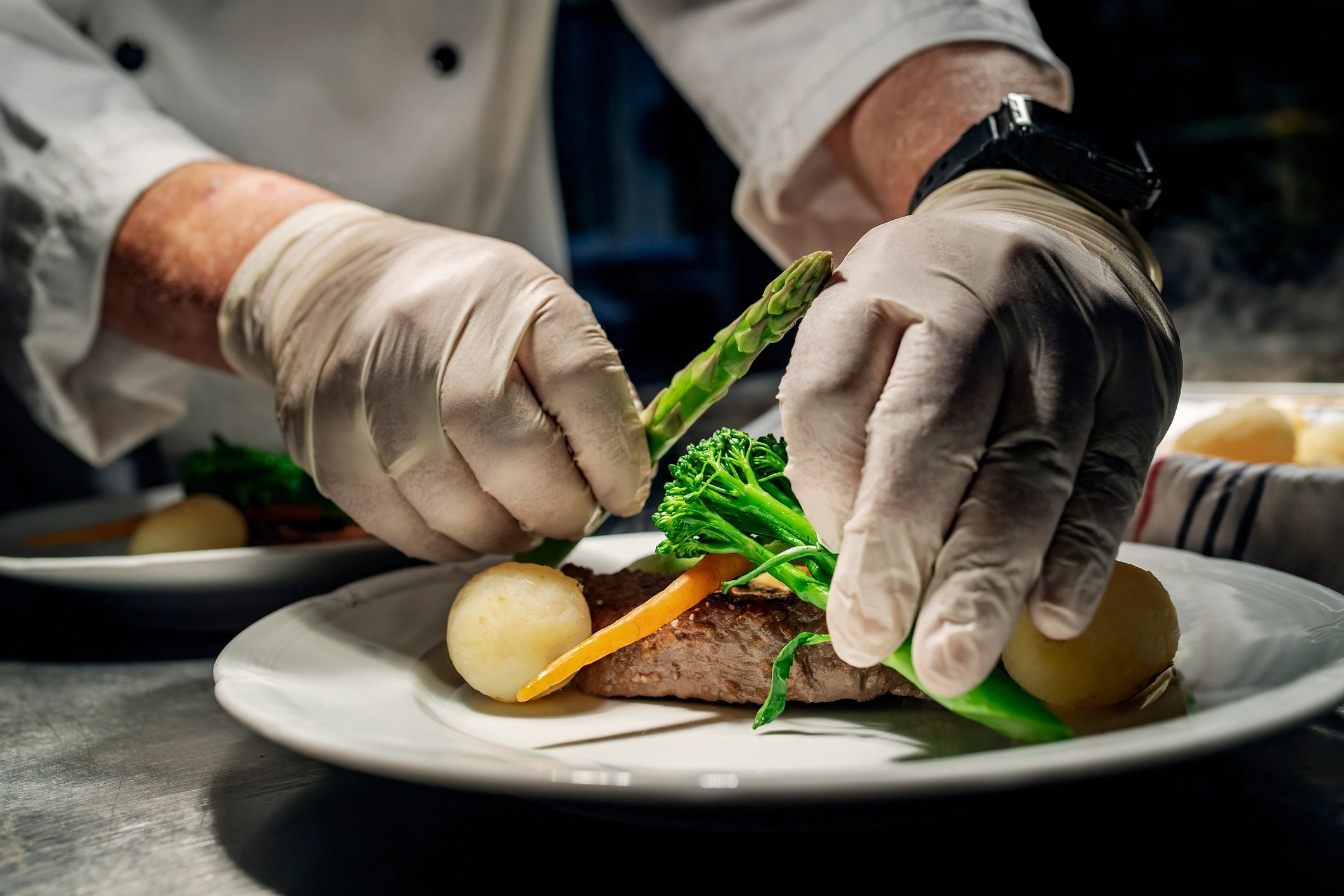 Chef preparing a plated dish in a kitchen