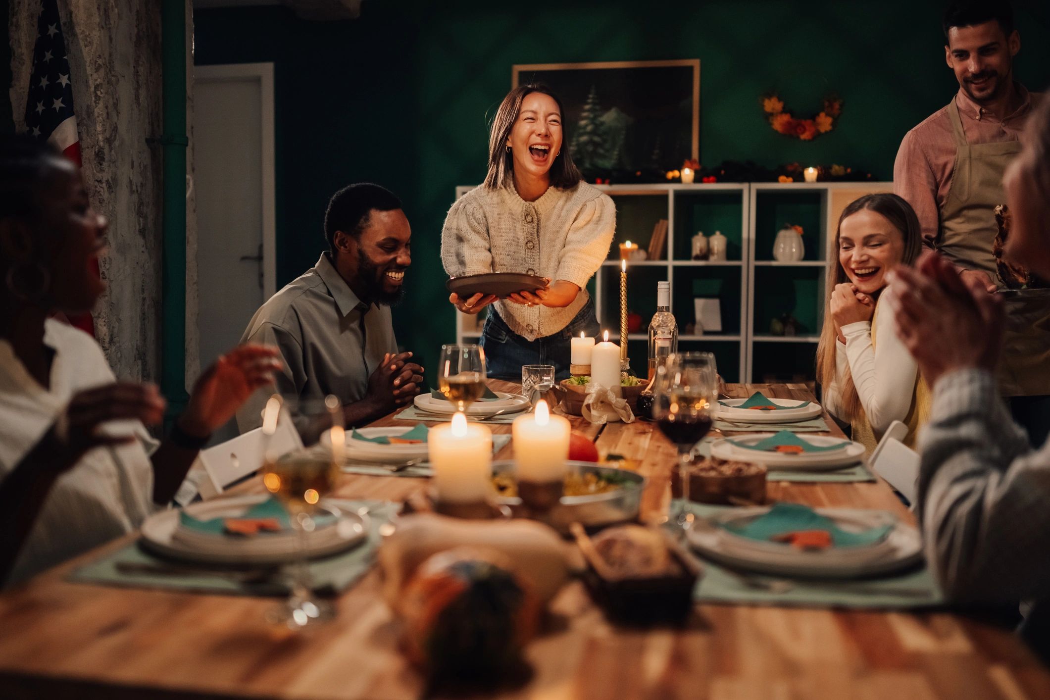 Friends laughing together at a festive dinner table