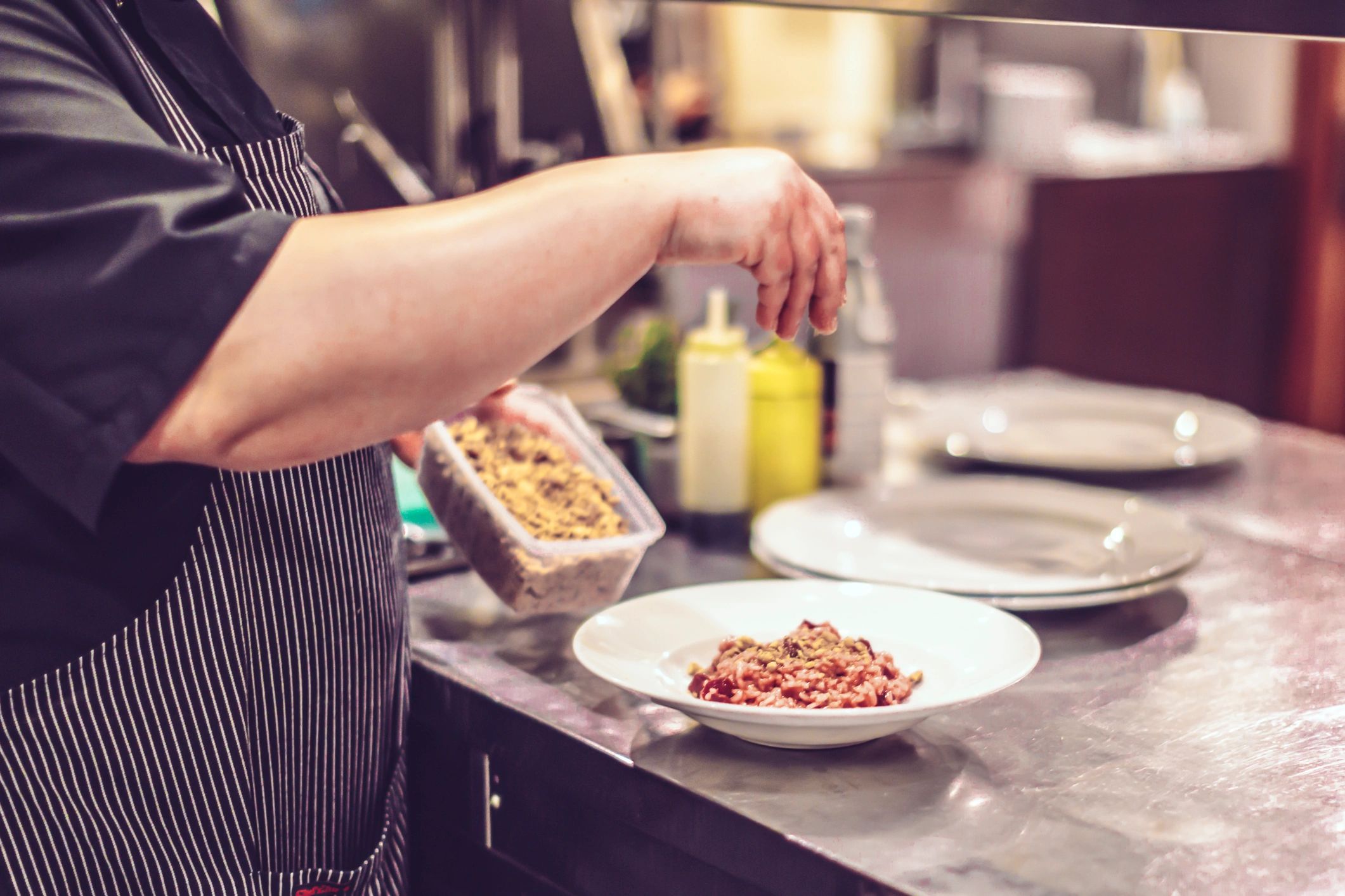 Cook plating a dish in a kitchen